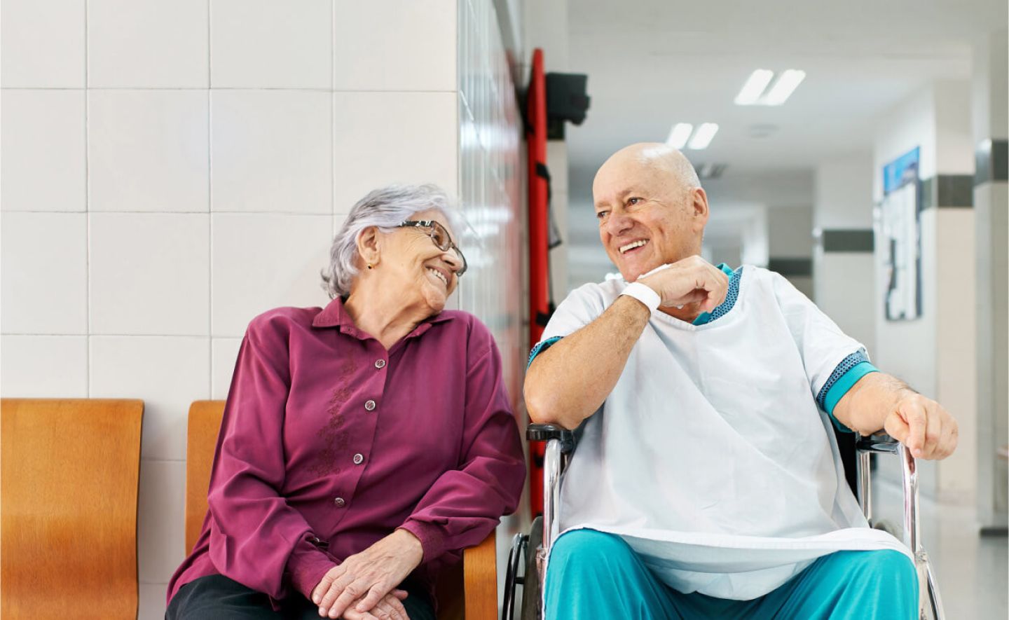 Two senior patients chatting in waiting room