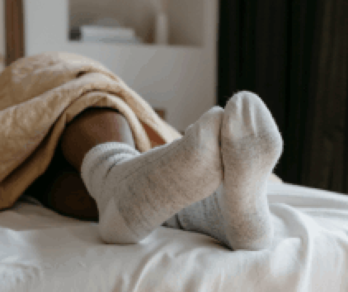 Patient lay on bed show feet with socks